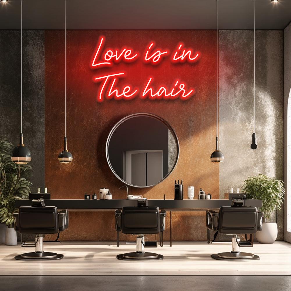 Red Love Is In The Hair neon sign above a round mirror and styling chairs in a salon concept