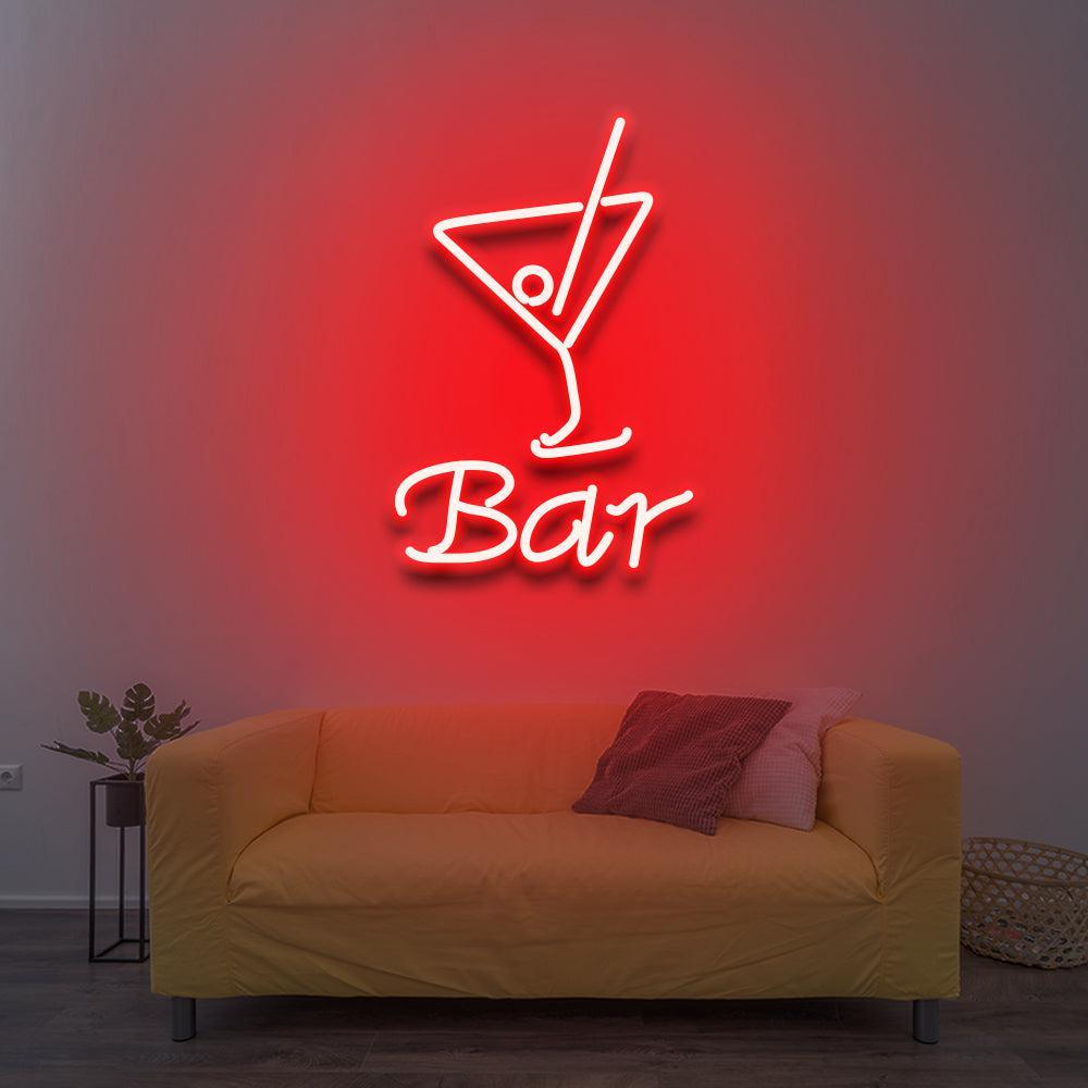 Cocktail-glass outline and Bar lettering glowing red and white above a mustard sofa